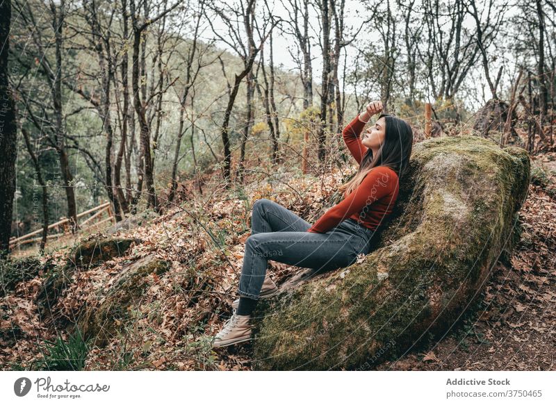 Carefree woman resting in forest on stone travel relax moss tranquil calm woods female valle del jerte caceres spain traveler harmony sit young rock summer