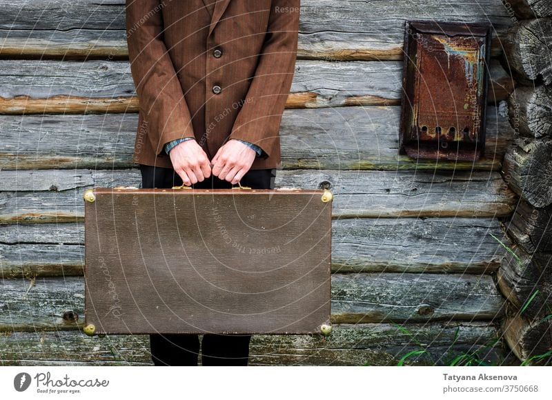 Man hipster with old retro suitcase near old country house man countryside cottagecore vintage summer brown field green jacket rustic travel young male