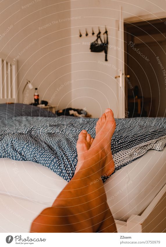 Young man relaxes in the bedroom Bed at home Relaxation relaxation dwell Cozy Old building Lie rest Write Weekend free time Bedroom Morning Lifestyle Legs feet