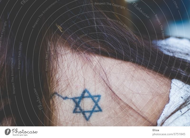 The Star of David, symbol of Judaism, as tattoo on the back of a woman with long brown hair Tattoo religion religious Belief devout Youth Young woman brunette