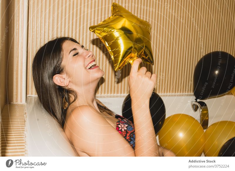 Young woman in bathtub with balloons after party - a Royalty Free Stock  Photo from Photocase
