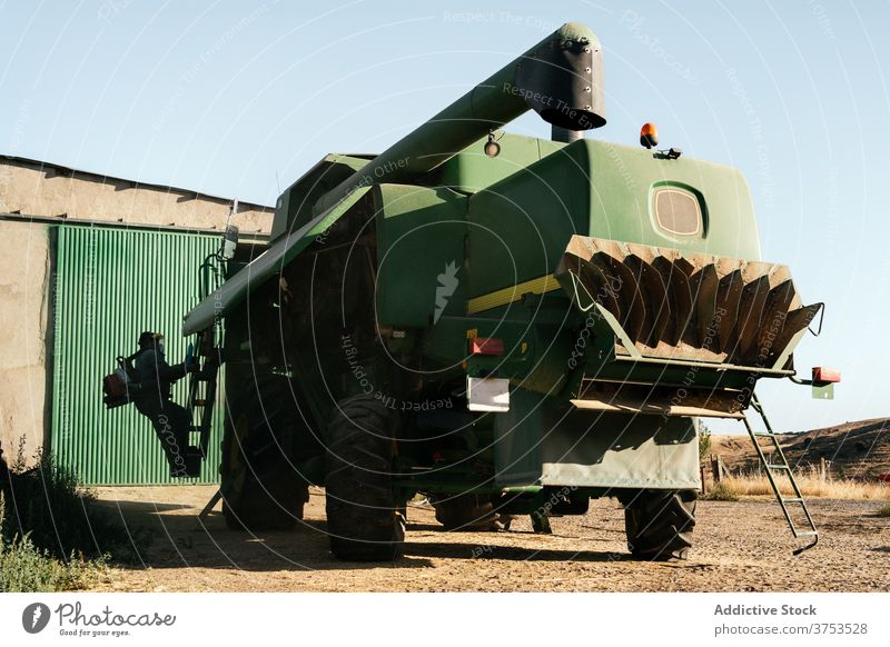 Agricultural machine parked in farm yard harvester combine agriculture vehicle farmland transport machinery car mechanism maintenance season countryside rural