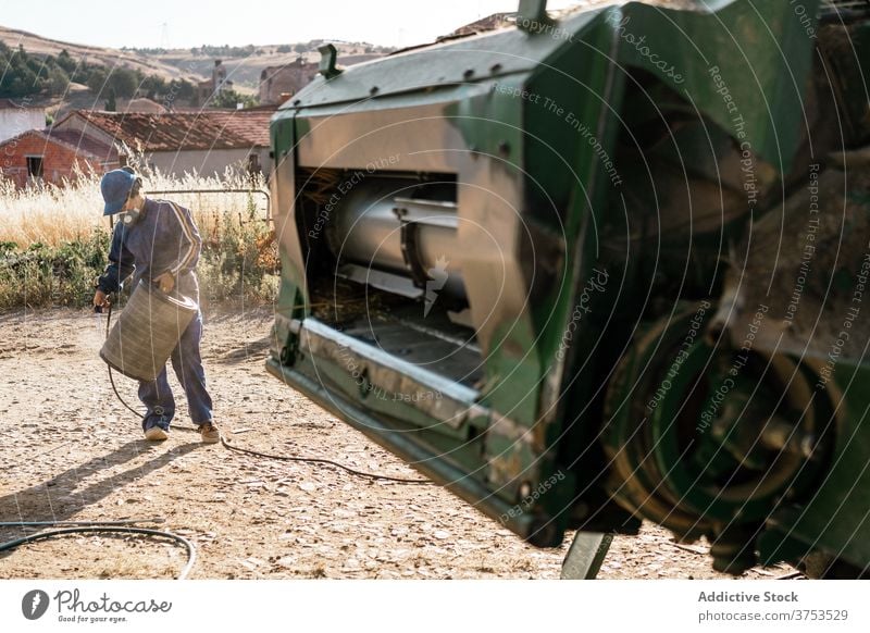 Farmer repairing detail of agricultural machine farmer harvester combine agriculture vehicle maintenance filter hydraulic farmland transport machinery car