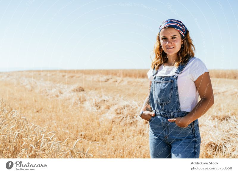 Content woman standing dry field wheat agriculture enjoy summer golden season carefree female landscape rural vacation country countryside nature sky idyllic