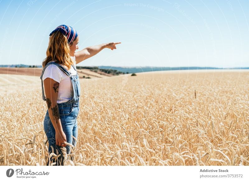 Woman in golden field in summer wheat woman countryside farmer agriculture nature rural female denim overall meadow freedom stand farmland harvest carefree