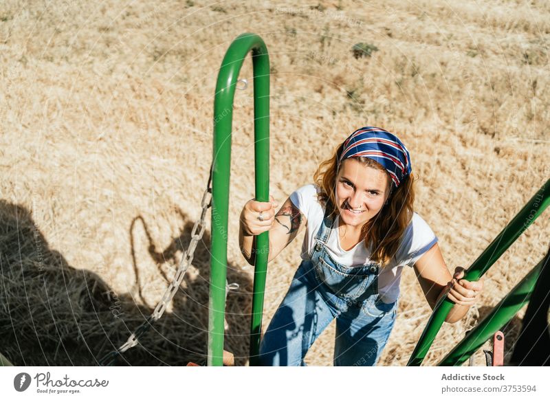 Woman on steps of combine harvester machine woman field farmer wheat countryside transport female summer nature agriculture rural season plant work growth