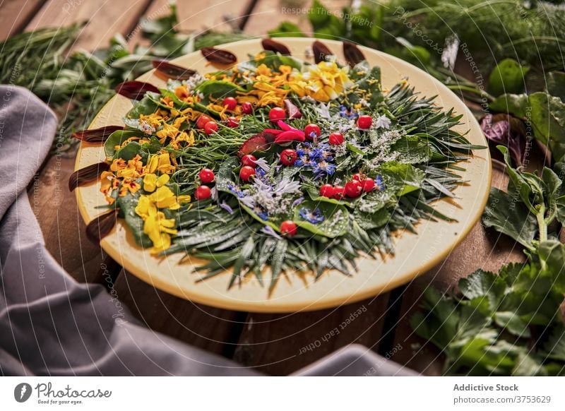 Delicious greenery with flower petals on plate composition herb arrangement wooden table ripe fresh nature summer bloom flora healthy season floral plant