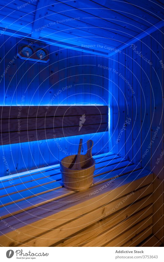 Interior of wooden sauna with ultraviolet lights interior bench illuminate detail recreation area lamp style decor design empty public place classic comfort