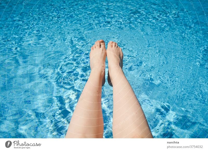 White woman legs against a turquoise pool water summer feet holidays fresh freshness white caucasian sun sunny protect health white skin barefeet foot enjoy
