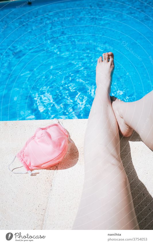 Woman legs in a swimming pool near a protective pink mask summer covid feet holidays water fresh coronavirus freshness face mask cloth influenza contagious risk