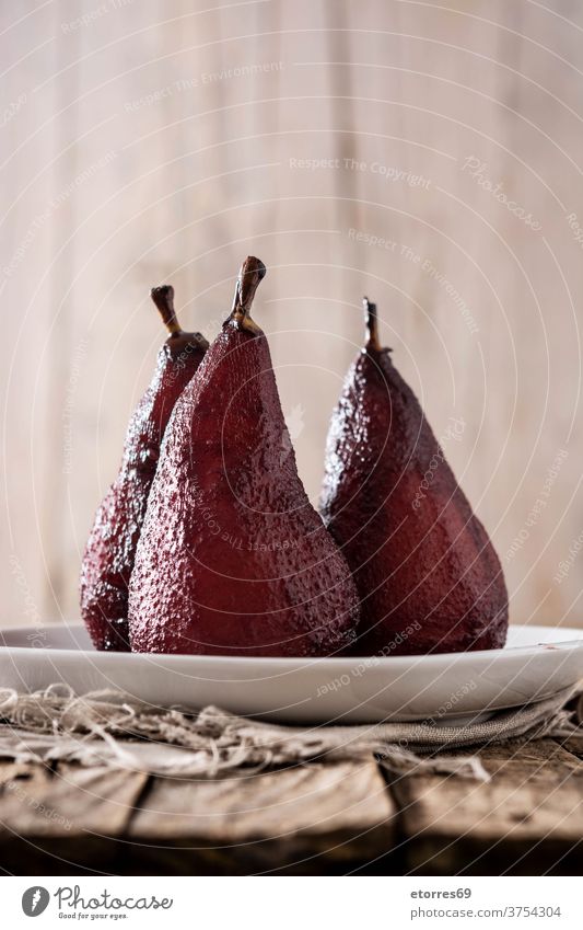 Poached pears in red wine boiled cinnamon cuisine delicious dessert food fruit gourmet homemade peel plate poached recipe spanish sugar sweet table wooden