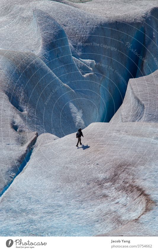 Walking by a glacier crevasse Glacier global warming ice melting snow Crevice Hiking outdoors Nature portrait one person Summer Blue