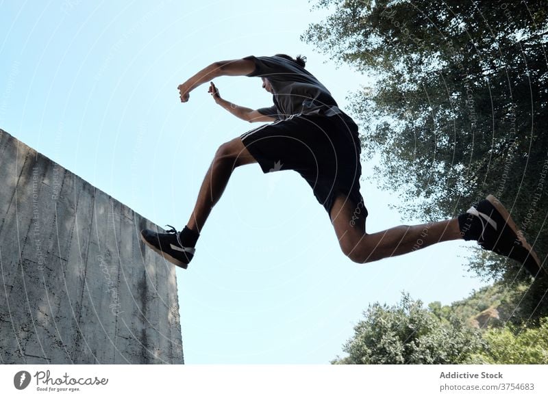 Man jumping above ground in city parkour man stunt trick urban extreme danger hobby male courage active handsome activity professional brave adrenalin energy