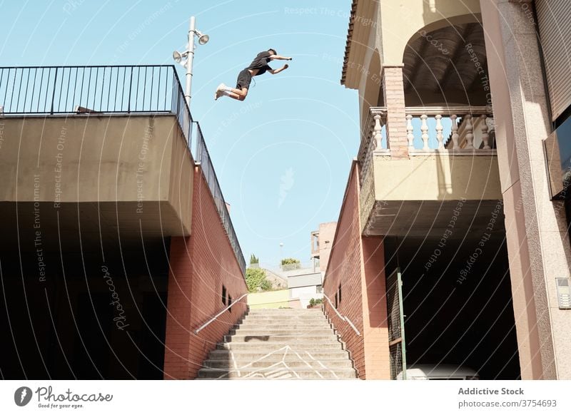 Man jumping over stairway in city parkour stunt trick man urban extreme danger hobby courage active activity professional brave adrenalin cool energy skill