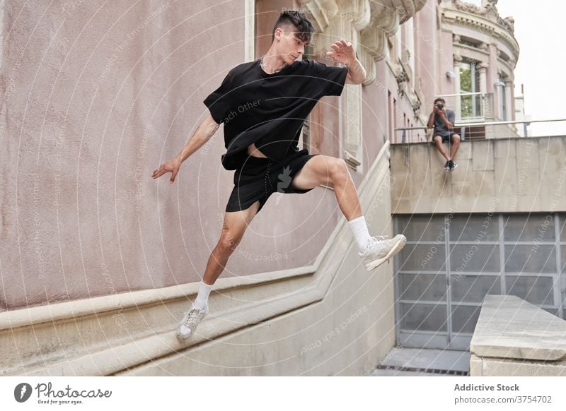 Strong man doing parkour on street jump obstacle stunt trick balance urban adrenalin extreme male city hobby courage active freestyle activity professional