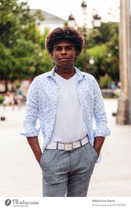 Pensive ethnic man on city street style trendy afro hairstyle weekend enjoy male black african american young urban casual handsome confident stand guy glad