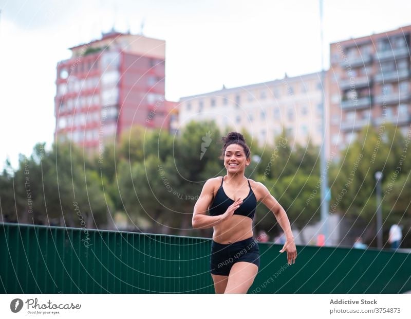 Strong black woman running in park runner strong city training cardio exercise speed female ethnic african american sportswear athlete fitness path urban