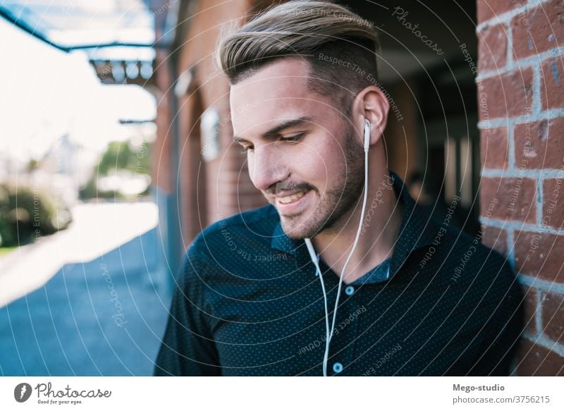 Man listening to music with earphones. person young people adult gadget outdoor technology lifestyle male casual alone sound entertainment city activity