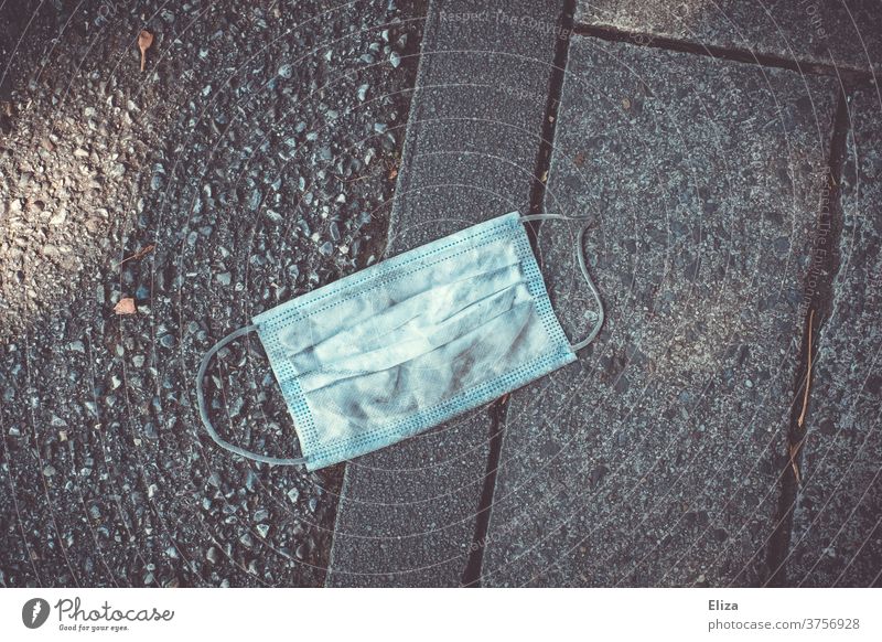 A used face mask Mouth mask Mouth nose protection is lying outside on the floor Mask Second-hand Dirty Mouth protection Mouth Nose Cover corona covid-19