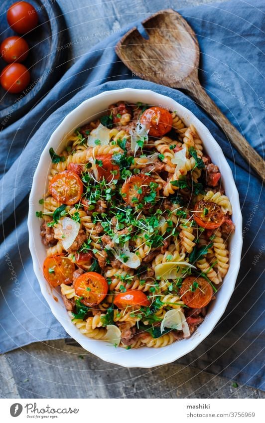 cooking tasty comfort food - italian fusilli pasta baked with meat sauce, cherry tomatoes and cheese lunch dinner plate dish vegetable basil cuisine red cooked