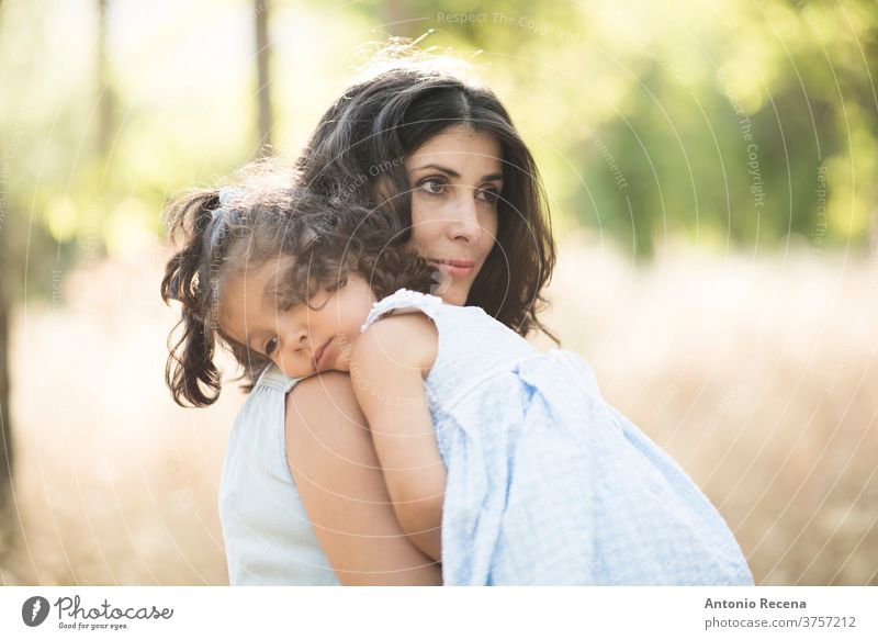 Woman with daughter in outdoors image. Sad daughter pregnant woman mother motherhood baby belly crying comforting sad carry in arms care 3 years girls