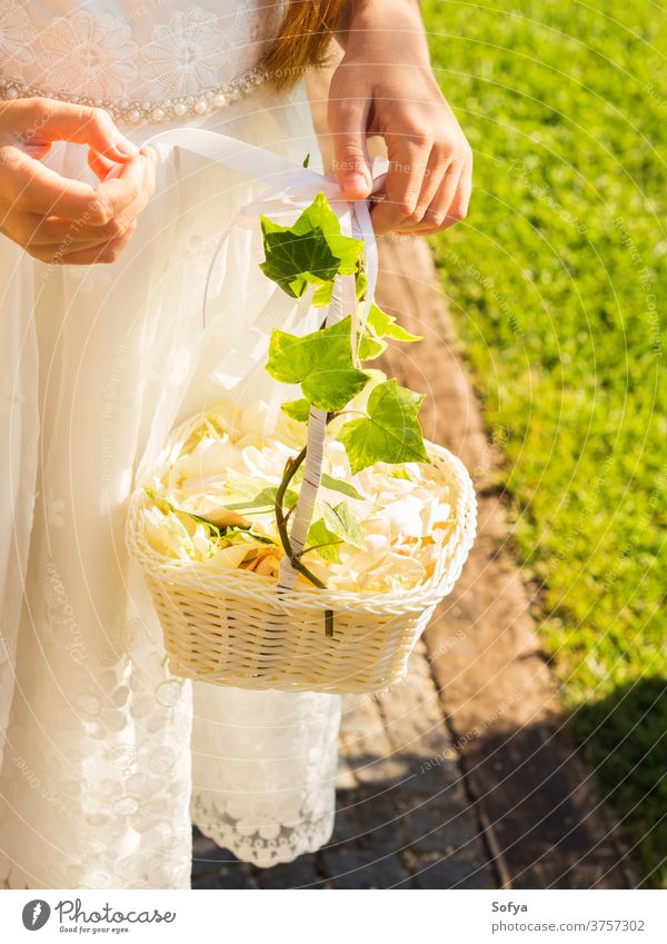 Flower girl in white dress with basket of petals wedding flower bridesmaid rose child fashion floral party summer kid nature sun bouquet beautiful little pretty