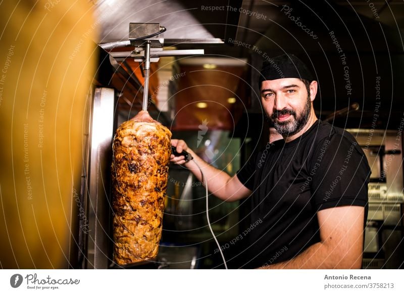 Bearded man preparing kebab meat in pizza bar. turkish adult person people lifestyle attractive men male bearded seller store junk food business night smile