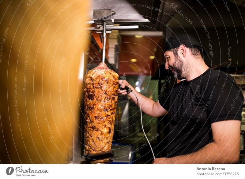 Bearded man preparing kebab meat in pizza bar. turkish adult person people lifestyle attractive men male bearded store junk food business portion night smile