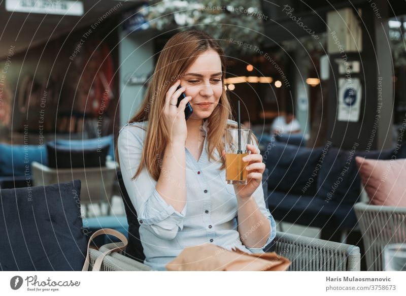 Young woman smiling with mobile phone in hands on lunch break adult attractive beautiful business businesswoman cafe coffee coffee shop communication face mask