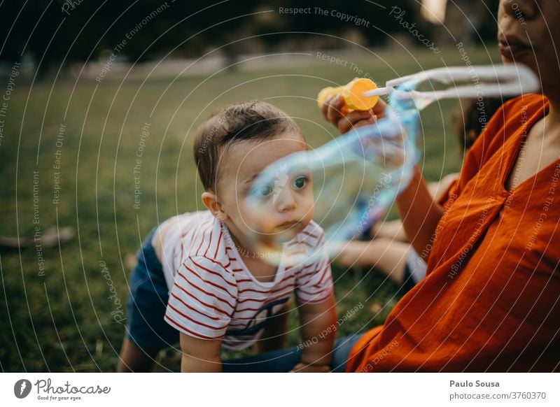 Mother and child playing with soap bubbles Soap bubble Playing Leisure and hobbies motherhood Toddler outdoors Caucasian Authentic Lifestyle Colour photo Happy