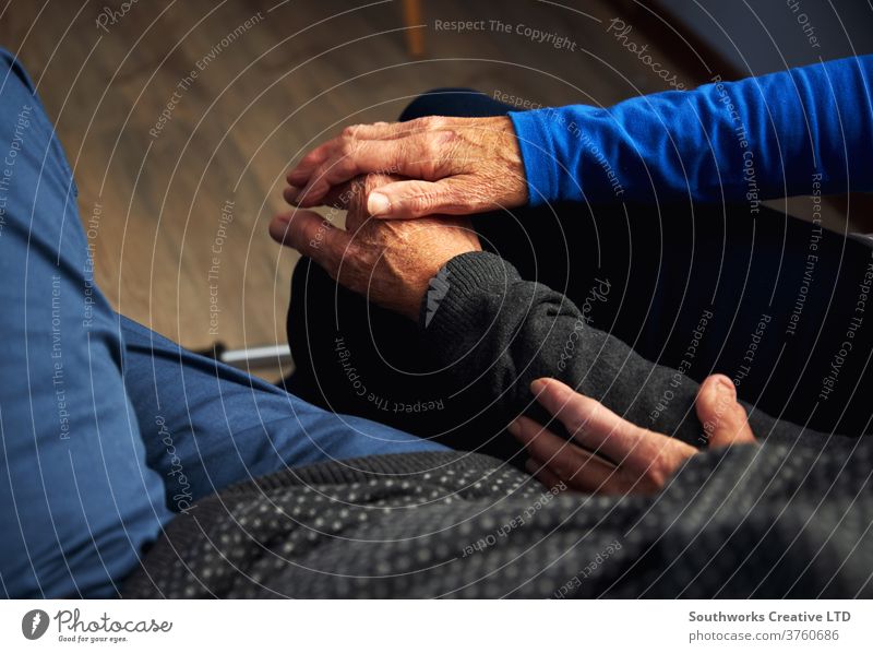 Older couple holding hands on the sofa Senior citizen care Participation Love Man Wrinkled Resting Relaxation Home Bond people Lifestyle indoors more adult