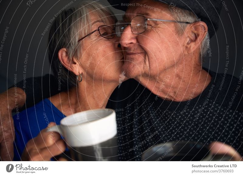 Happy senior couple kissing and laughing happy elderly smiling 70 70's hipster maturity grey-haired elderly people baby boomers loving married care two people