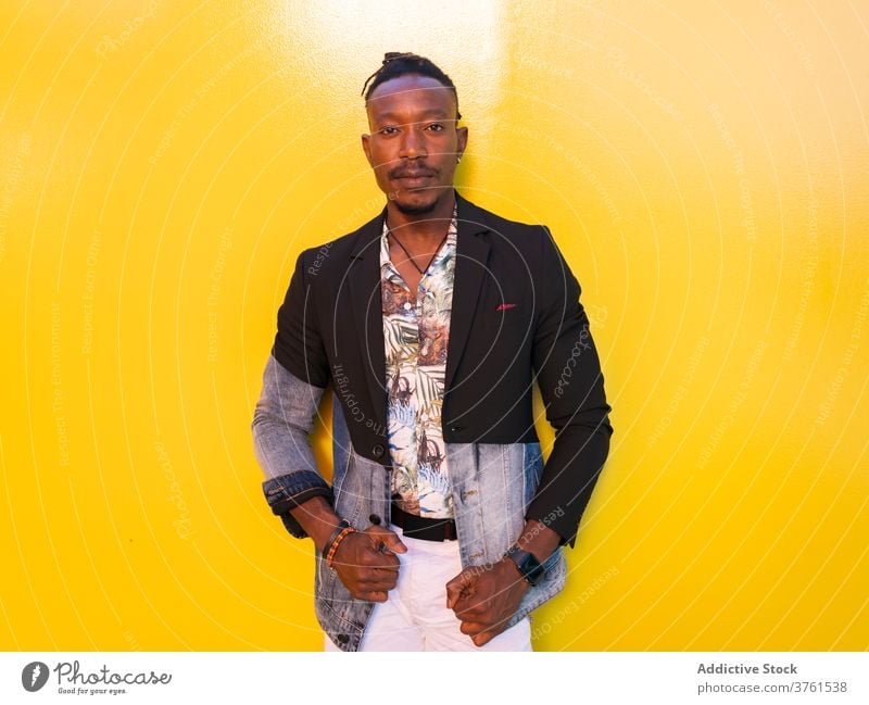 Confident ethnic man in stylish wear in city model fancy style apparel vivid yellow wall trendy male black african american fashion outfit urban confident