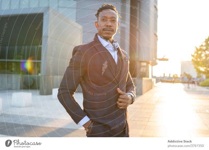 Confident businessman in stylish suit in city classy entrepreneur determine serious sunlight downtown metropolis male ethnic black african american center urban