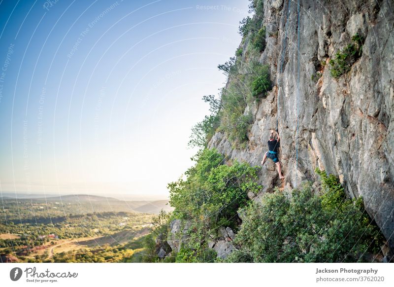 Man climbing a rock man portugal outdoor park nature high climber active activity adrenaline adventure algarve brave carbines challenge cliff determination edge