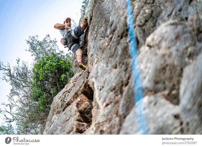 A man climbing a rock with a harness climber portugal adventure outdoor park nature high active activity adrenaline algarve brave carbines challenge people