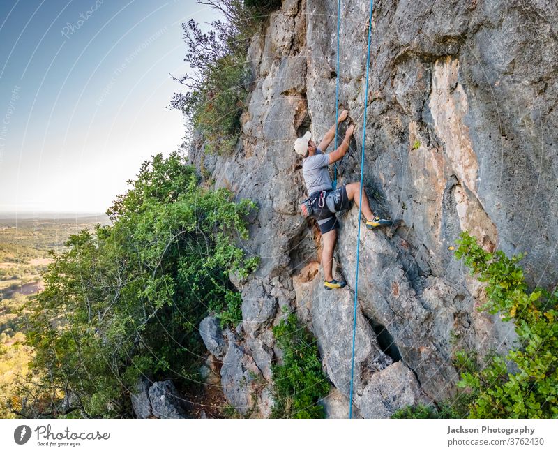 Climber with harness on huge rock sport climber climbing man active activity adrenaline adventure algarve brave carbines challenge cliff determination edge