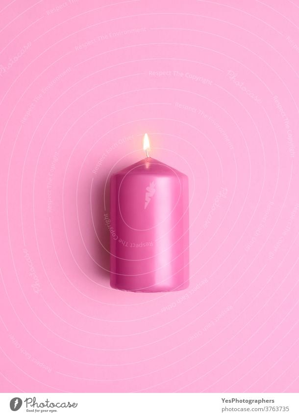 Lit candle isolated on a pink background. Aromatic pink candle burning advent anniversary aromatic bright candlelight celebration ceremony christmas copy space