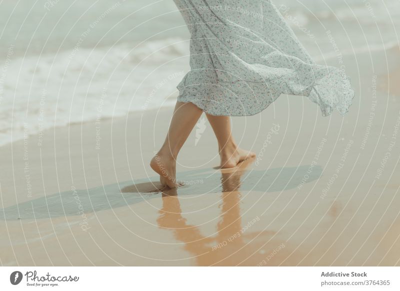 Anonymous woman in dress walking on sandy beach barefoot leg shore coast alone pure sea gentle female spain valencia el saler beach nature romantic freedom
