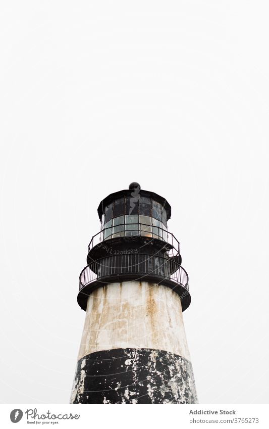 Shabby lighthouse against gray sky beacon shabby old building weathered overcast aged usa america united states architecture exterior cloudy ancient peaceful