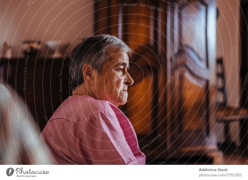 Senior woman sitting alone on the sofa at home old loneliness indoors alzheimer mental health one person retirement memory aged home interior grandmother senior