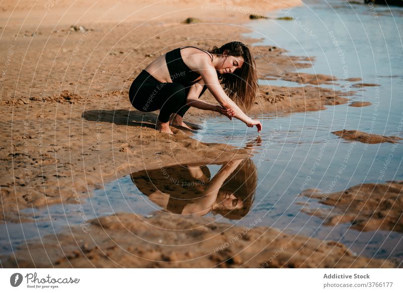 Calm woman washing arms in river clear water clean summer tranquil beach female shore creek coast idyllic peaceful serene daytime calm harmony nature lady