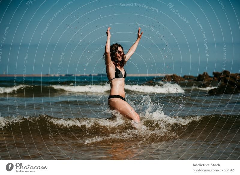 Carefree woman running in sea water having fun splash summer vacation holiday bikini female shallow resort relax carefree happy smile nature rest young delight