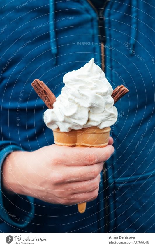 Soft vanilla ice cream with chocolate stick soft cone hand soft ice cream takeaway treat confectionery creamy cornet milk icecream tasty white sweet food