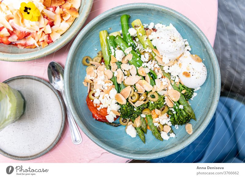 Healthy Breakfast with poached eggs Brunch Trendy Cafe roasted red pepper tenderstem broccoli asparagus romesco sauce olives toasted almonds feta many plates