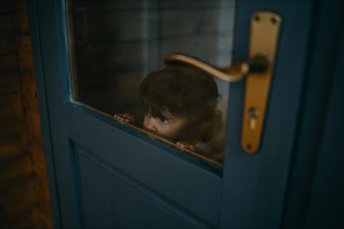 Child looking through door childhood Looking Door Glass Caucasian Christmas & Advent confinement Quarantine at home Home caucasian stay at home Colour photo