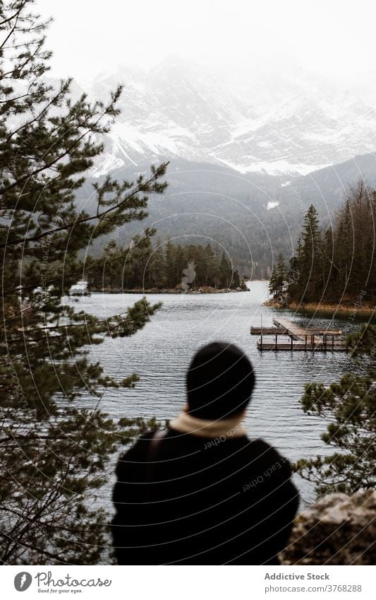 Traveler near lake in highlands mountain winter traveler admire landscape season snow cold germany austria scenery explorer tourism vacation peaceful relax calm