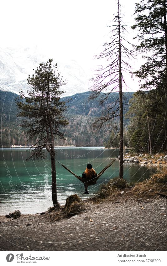 Woman relaxing in hammock near lake woman mountain admire scenery pond highland autumn female germany austria majestic nature traveler serene tourism peaceful