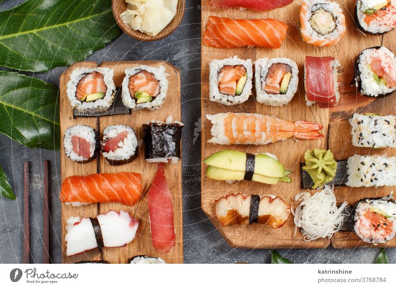 Sushi Set nigiri and sushi rolls on rectangular wooden plates - a