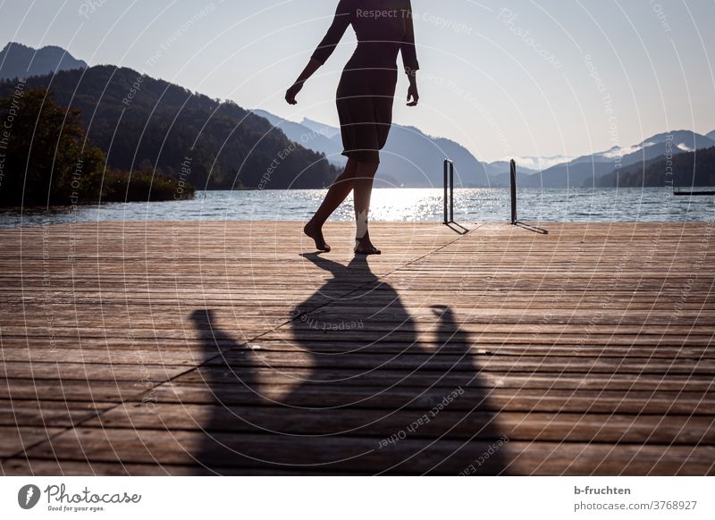 Dance in the morning sun, woman on a wooden jetty, against the light Footbridge Lake Water Woman dance Summer Sun Relaxation Nature Vacation & Travel Calm